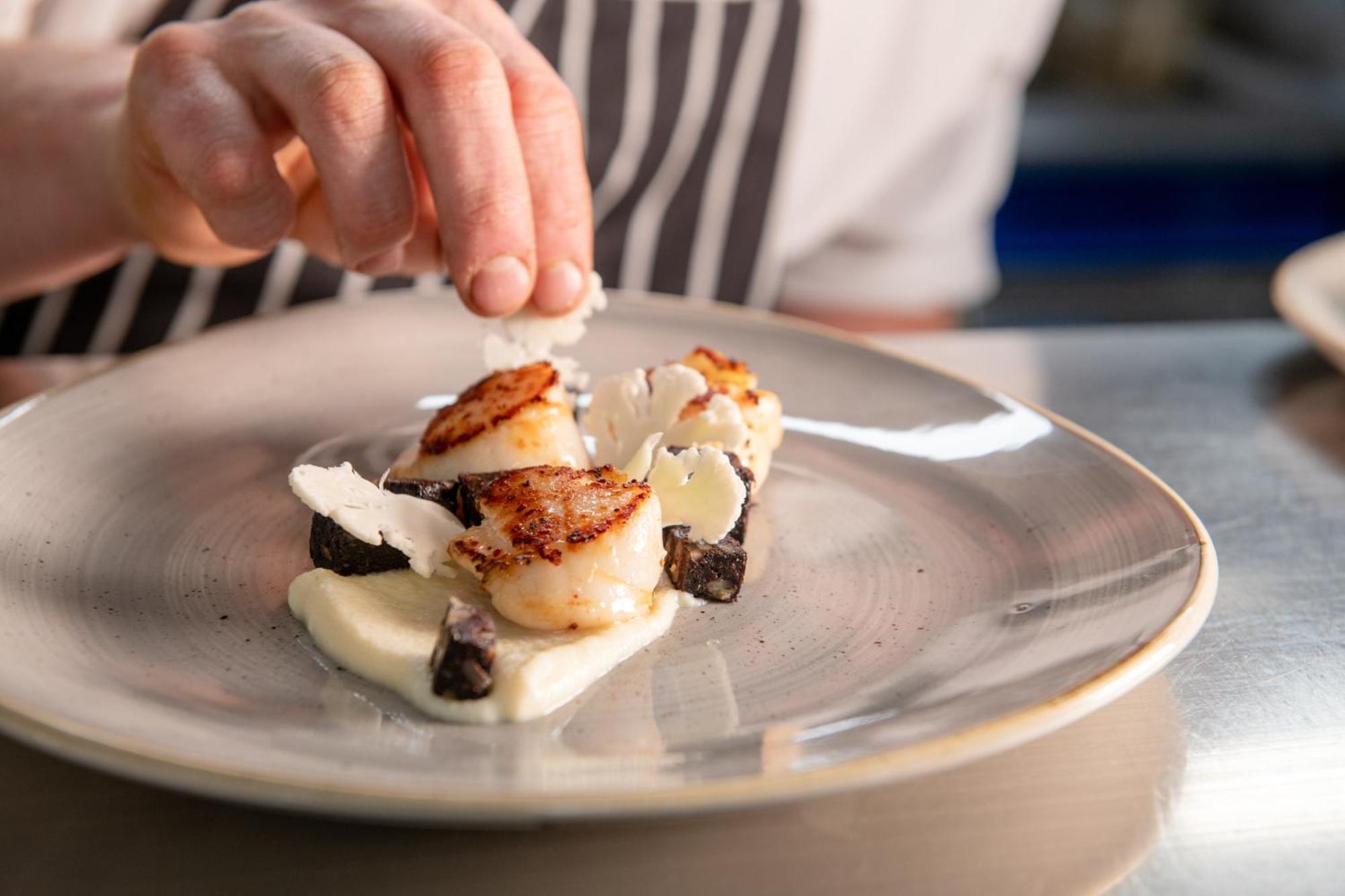 The Millstone, Mellor Hotel Blackburn  Bagian luar foto A chef finishing a plate of scallops